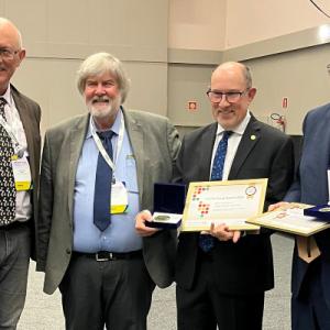 Heitman accepting award standing next to three colleagues